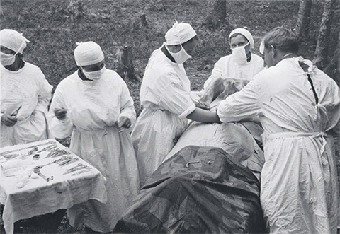 Хирурги оперируют раненого в полевом госпитале
